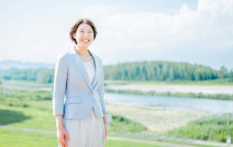 晴れ渡る河川敷に立つ由季菜さん